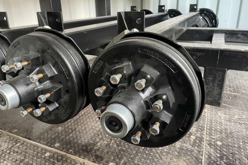 Flexiride torsion axles sitting on a rack ready to be installed on a custom trailer
